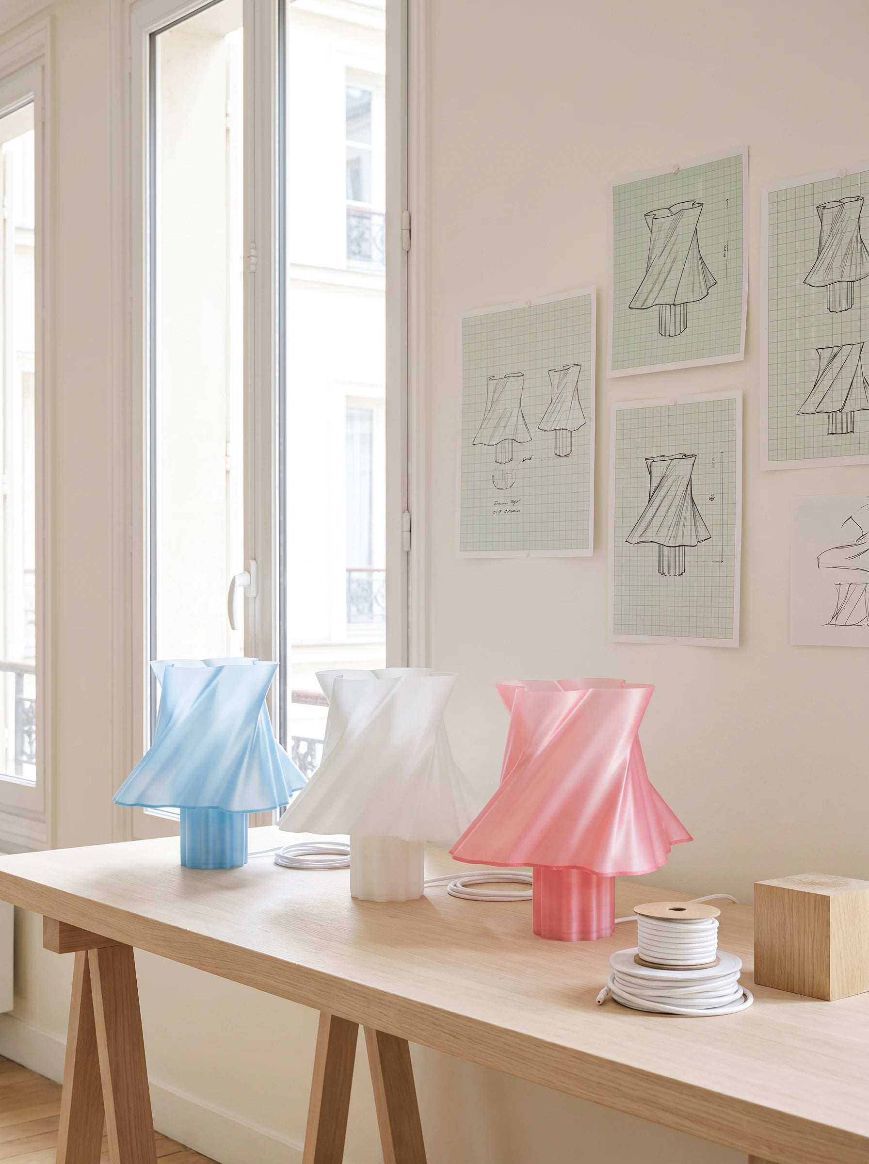 Lampes Cloud Dancer dans un atelier parisien entouré de croquis de design — savoir-faire créatif — LUMY PARIS