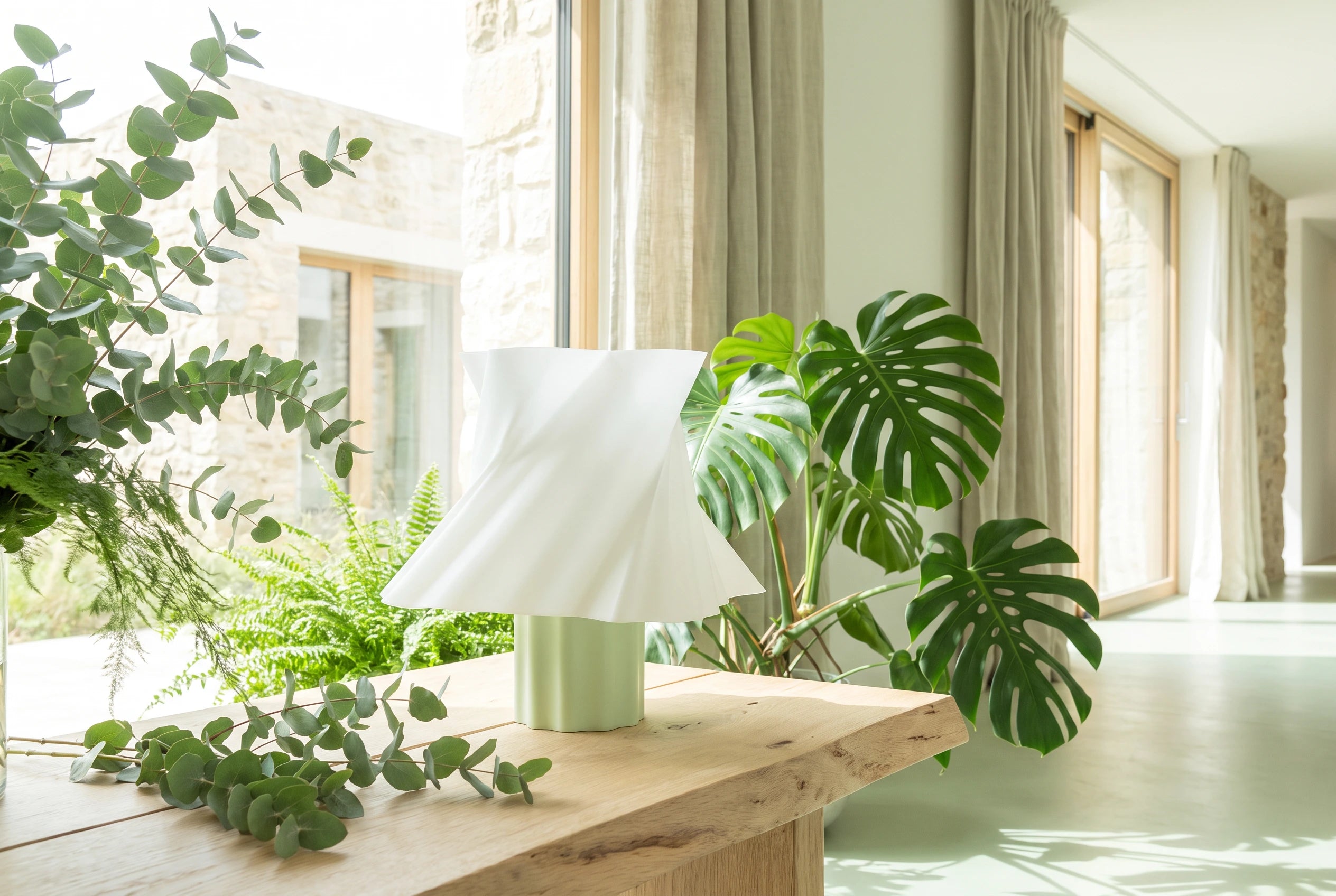 Lampe Cloud Dancer coloris vert mint entourée de plantes vertes sur table bois — esprit nature — LUMY PARIS