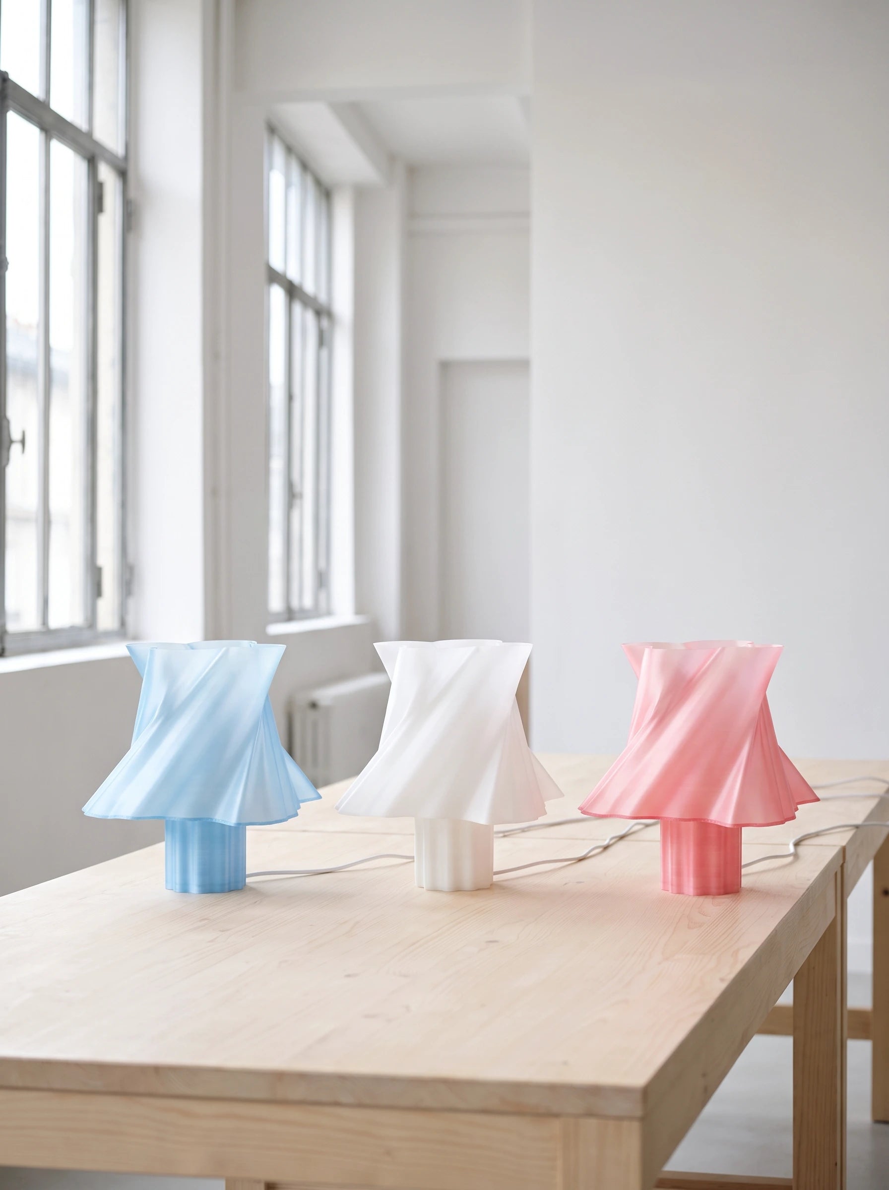 Trio de lampes design Cloud Dancer dans un atelier industriel lumineux — bleu, blanc, rose — LUMY PARIS