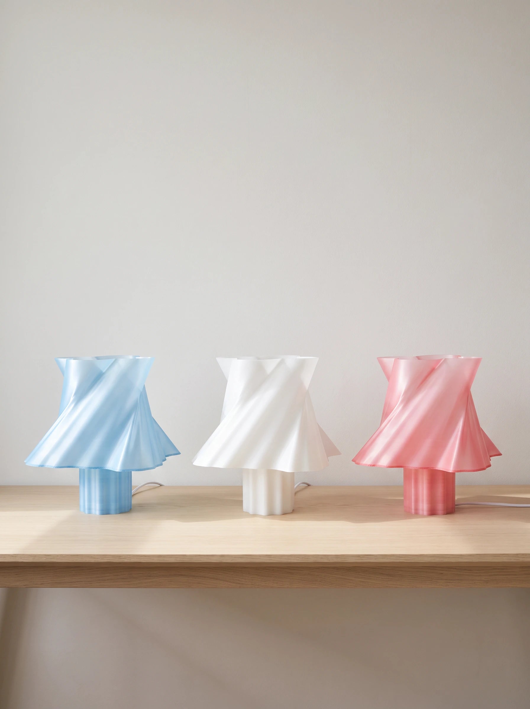 Trio de lampes design Cloud Dancer coloris bleu, blanc et rose sur table bois — collection — LUMY PARIS
